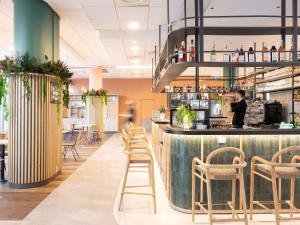 un bar avec des tabourets dans un restaurant dans l'établissement ibis Marseille Centre Euromed, à Marseille