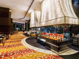 a hotel lobby with a large aquarium in the middle at Sofitel Mumbai BKC in Mumbai