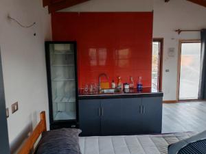 a kitchen with a sink and a red wall at Cabañas Mirador de Maitencillo 2 in Maitencillo