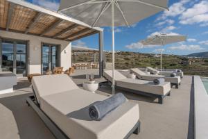 een patio met banken en parasols bij Avera Villas in Parikia