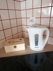 une bouilloire sur un comptoir à côté d'une boîte dans l'établissement Location d'un chalet de vacances, à Pont-de-Poitte