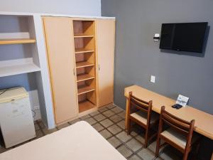 a room with a table and chairs and a cabinet at Pousada Casa Grande in Bonito