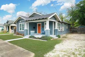 a blue house with a red door in a yard at Lone Star Landing in San Antonio