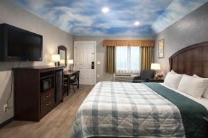 une chambre d'hôtel avec un lit et une télévision à écran plat dans l'établissement Hotel O Regency Suites Houston - IAH Beltway 8, à Houston