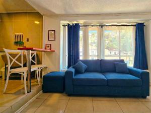 a living room with a blue couch and a table at La Galería B&B in Valparaíso