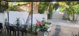 een terras met een tafel, stoelen en planten bij Casa campestre plata cerca in Puerto Colombia