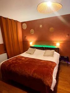 a bedroom with a large bed with a light on it at Nali Room in La Vespière