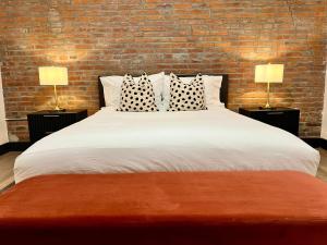 a bedroom with a large white bed with two lamps at Brick & Bed Riverfront Lofts, T 302 in Saint Louis