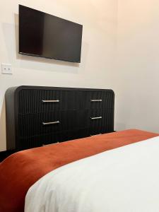 a bedroom with a bed and a dresser with a flat screen tv at Brick & Bed Riverfront Lofts, T 302 in Saint Louis