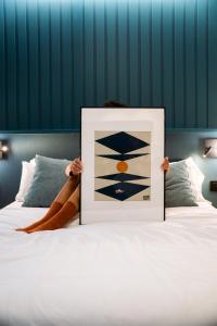 een persoon die een foto op een bed omhoog houdt bij BYPILLOW Bilbo in Bilbao