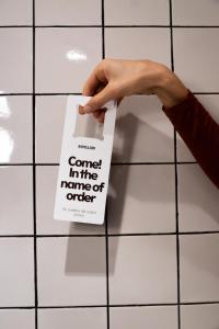 Een hand die een bord vasthoudt op een witte tegelvloer. bij BYPILLOW Bilbo in Bilbao +25 foto's