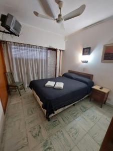 een slaapkamer met een bed met twee handdoeken erop bij Florencia Apartamentos y habitaciones in Necochea