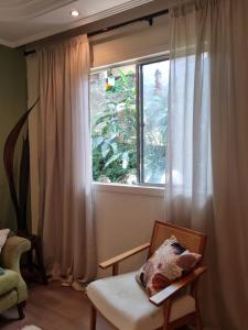 una camera con finestra e sedia con cuscino di Jasmim 12 a Santo André