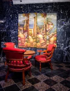 two chairs and a table in a room with a painting at GALLANISUITES hotels in Ibadan