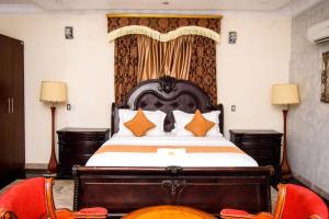 a bedroom with a large bed with orange pillows at GALLANISUITES hotels in Ibadan