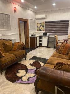 a living room with two couches and a kitchen at GALLANISUITES hotels in Ibadan
