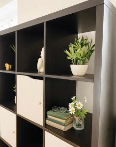 een boekenplank met boeken en bloemen erop bij Crown Heights Executive Apartment in Manchester
