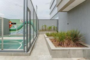 a fence with a basketball court on the side of a building at Aptos em Prédio com Piscina e Academia - GRL in Anápolis