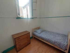een slaapkamer met een bed, een ladekast en een raam bij La Mancha Art Hostel in Valparaíso +9 foto's