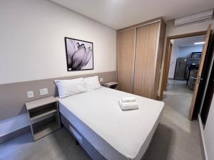 a bedroom with a large white bed in a room at Aptos em Prédio com Piscina e Academia - GRL in Anápolis +43 photos