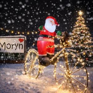 een kerstman in een koets voor een kerstboom bij MoryńApartments in Moryń