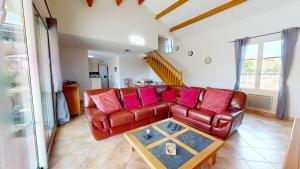 a living room with a leather couch and a table at Villa BlueGreen in Coëx