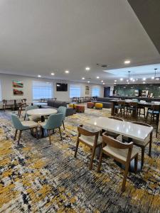 una grande stanza con tavoli, sedie e un divano di La Quinta Inn & Suites by Wyndham Minot a Minot