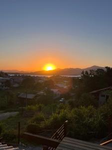 een zonsondergang boven een stad met zonsondergang bij Residencial Bambu in Garopaba