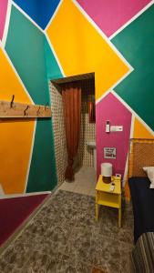 une chambre avec un mur coloré, un lit et une table dans l'établissement Mango Haus, à Aqaba