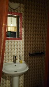 une salle de bains avec un lavabo blanc et un miroir dans l'établissement Mango Haus, à Aqaba