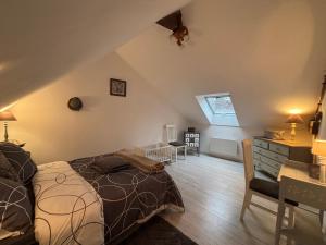een slaapkamer met een bed, een bureau en een stoel bij Gîte du Palais 3 étoiles in Châteauneuf-sur-Cher