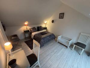 een slaapkamer met een bed, een tafel en een stoel bij Gîte du Palais 3 étoiles in Châteauneuf-sur-Cher