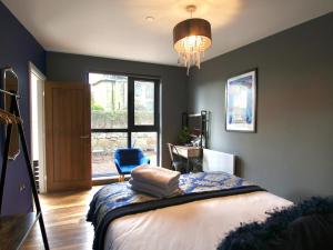 a bedroom with a bed and a chair and a chandelier at Narrowgate Castle Ocean Blue Lodge Central Alnwick Inc Sofa Bed in Alnwick