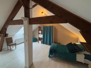 een zolderkamer met een bed en een raam bij Gîte du Palais 3 étoiles in Châteauneuf-sur-Cher +10 foto's