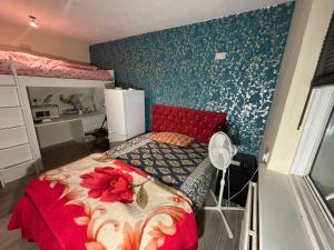 a bedroom with a red bed with a flower on it at SleepEasy Harrow in Harrow Weald