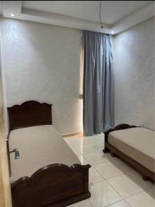 een slaapkamer met twee bedden en een raam bij Appartement standing 1 in Skhirat