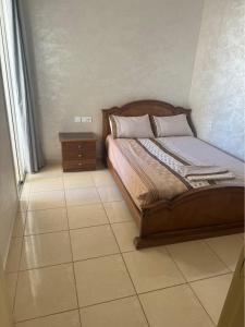 een slaapkamer met een bed en een tegelvloer bij Appartement standing 1 in Skhirat