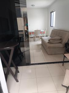 een woonkamer met een bank en een tafel bij Pajuçara Maceio Pé na Areia in Maceió