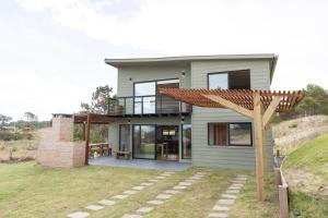 a house on top of a hill with a pergola at Orion in Punta Del Diablo