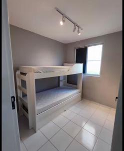 una piccola stanza con un letto e una finestra di Ótima localização 20 min Pajucara a Maceió 1 altra foto