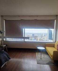 un soggiorno con una grande finestra e un divano giallo di Vue Panoramique a Puteaux