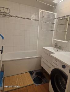 bagno con vasca, lavandino e lavatrice di Vue Panoramique a Puteaux