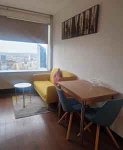 un soggiorno con un divano giallo e un tavolo di Vue Panoramique a Puteaux