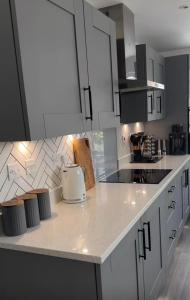 een keuken met witte kasten en een aanrechtblad bij kusum properties in Trofwi