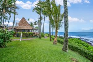 een resort met palmbomen voor de oceaan bij Napili Shores D125 in Honokowai