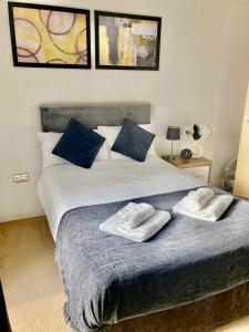 a bedroom with a bed with two towels on it at VIPAbodes at Woking Central in Woking