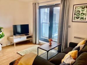 a living room with a couch and a tv at VIPAbodes at Woking Central in Woking