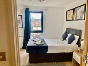a bedroom with a bed with blue curtains and a window at VIPAbodes at Woking Central in Woking