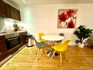 een keuken met een tafel en gele stoelen bij VIPAbodes at Woking Central in Woking