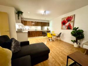 een woonkamer met een bank en een keuken bij VIPAbodes at Woking Central in Woking